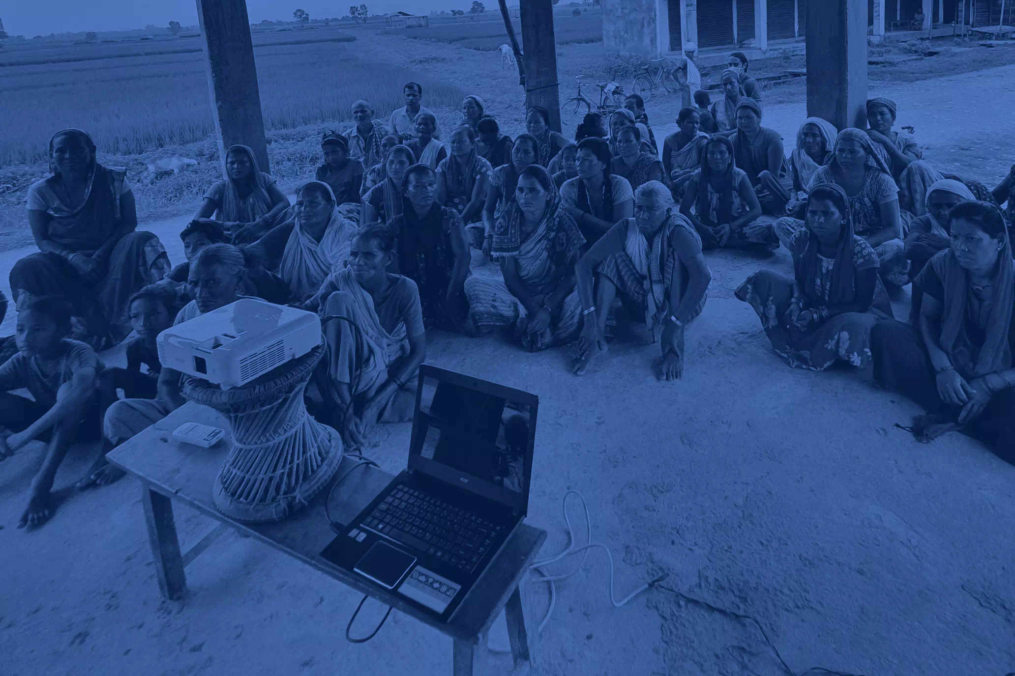 Farmers of rural Nepal gathered around a projector